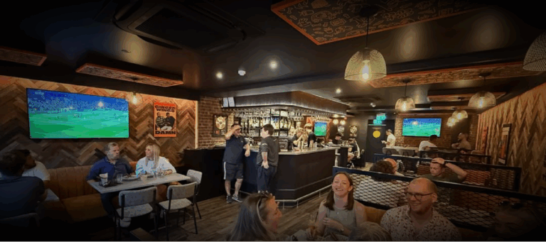 Interior of Ginger Wings bar showing installed audio and screen setup in use by guests